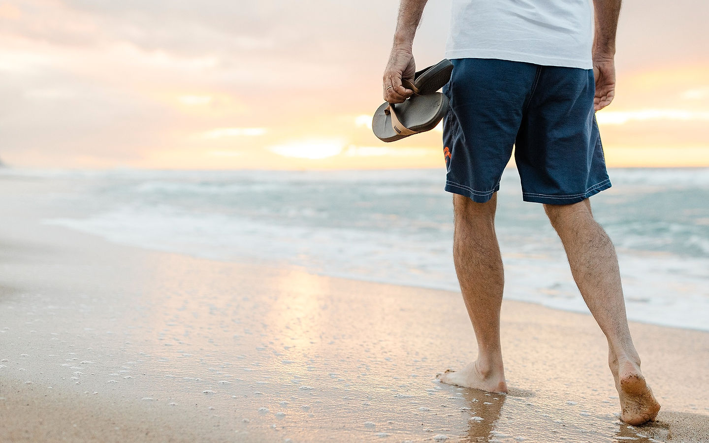 Walking barefoot on the beach at sunset - representing active, healthy living